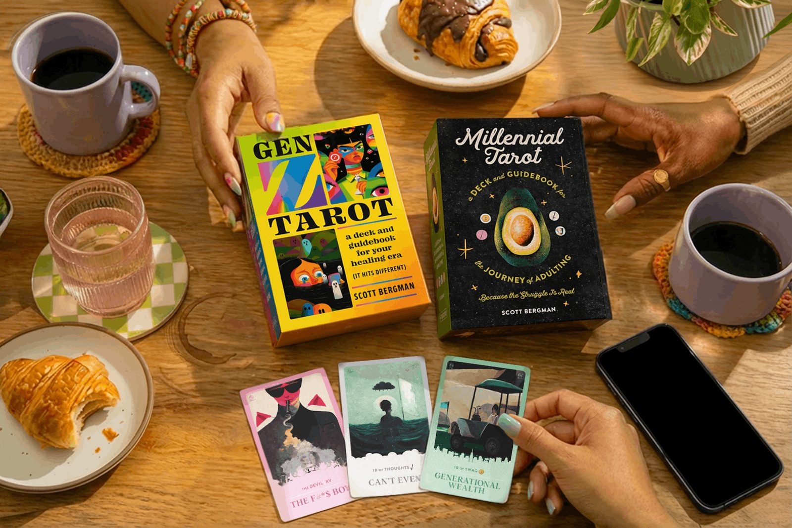 Both decks on a wooden table with a spread of cards mid-reading